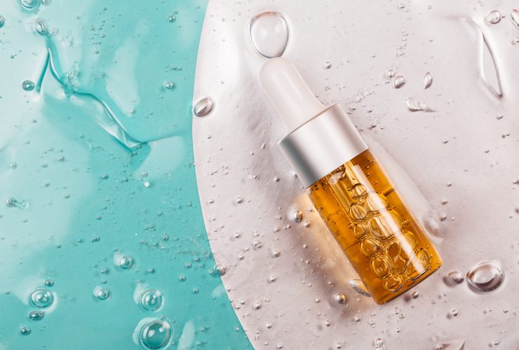 Bottle of hyaluronic acid on background with oxygen bubbles.